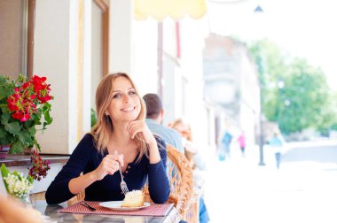Sokak café'de pasta yemeye çekici genç kadın.