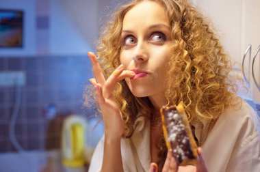 Geceleri mutfakta tatlı pasta yemeye komik genç kadın