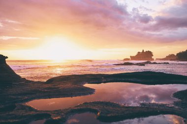  Antik Hinduizm Tapınağı Tanah lot bulutlu gökyüzü karşı kayaya. Bali Adası, Endonezya.