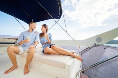 Modern yat güvertede kanepede oturan genç sevgi dolu çift