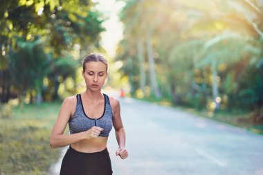 Genç ince kadın palmiye ağaçları altında çalışan.