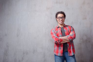 Geçti ve gri arka plan karşı dururken kamera seyir silah tutmak yakışıklı genç