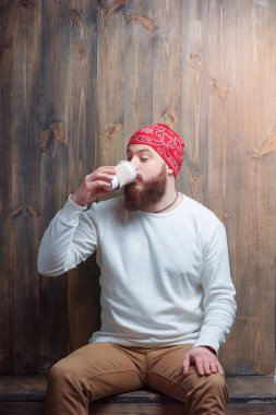 Genç adam içecek fincan içme sakallı.
