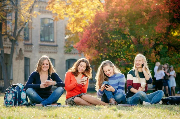 Group Smiling Girl Friends Smartphones Sitting Grass University Building Background — Stock Photo, Image