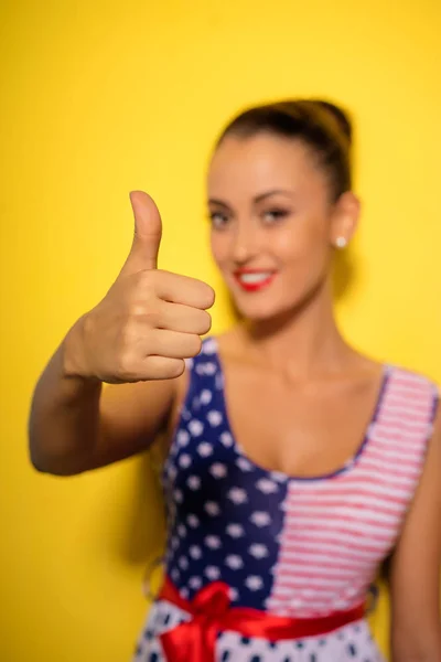 Szczęśliwa Młoda Kobieta Pokazuje Jej Kciuk Stojąc Żółtym Tle — Zdjęcie stockowe