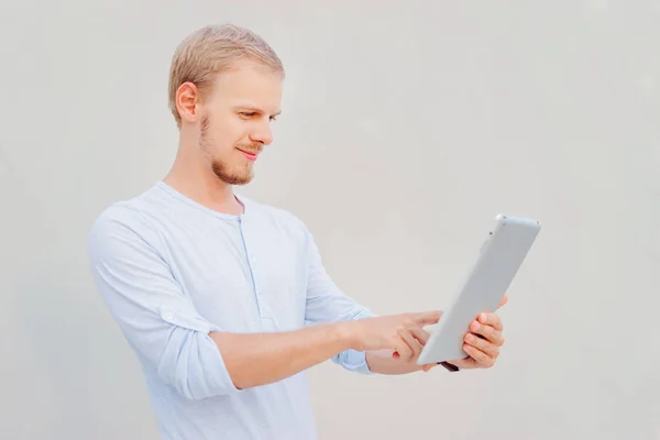 Csinos Fiatal Férfi Dolgozik Digitális Tabletta Míg Szürke Falnak — Stock Fotó