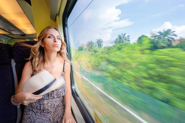 若い女性が窓のそばに座って電車旅行に疲れて — ストック写真