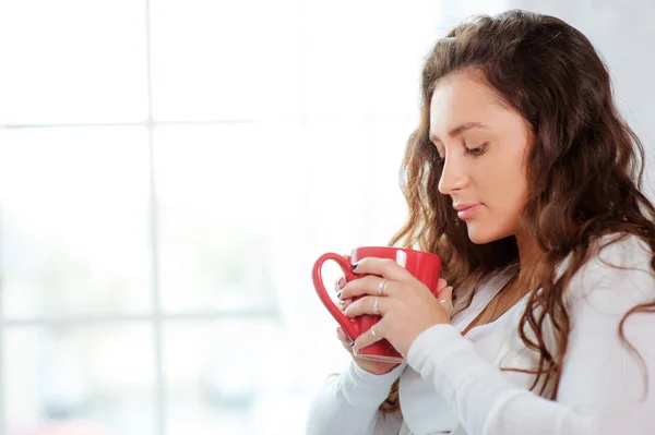 Mooie Jonge Vrouw Met Kopje Thee Zitten Tegen Het Raam — Stockfoto