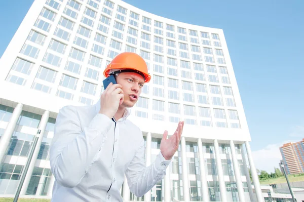 Excited Young Man Hardhat Talking Mobile Phone While Standing Outdoors — Stock Photo, Image