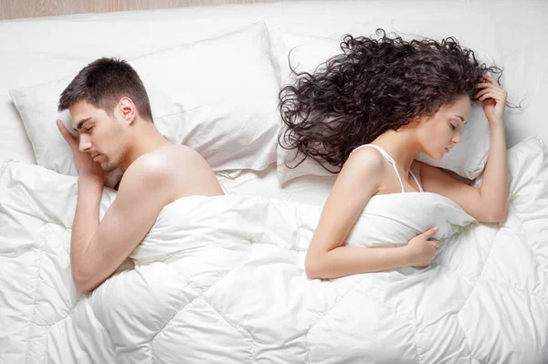 Top view of young couple lying on the bed.