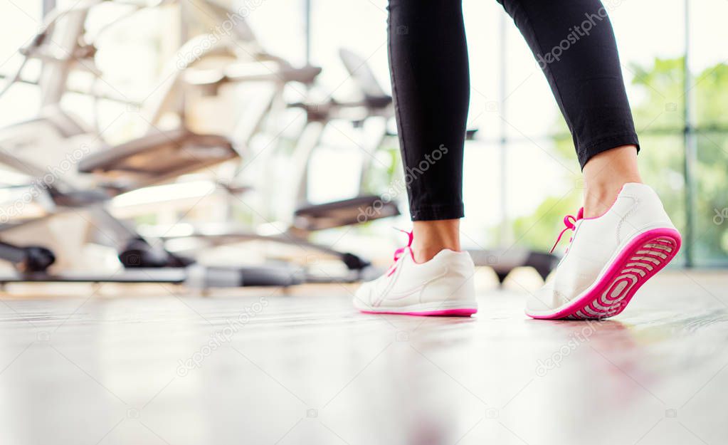 Close up of female feet in sneakers in gym.
