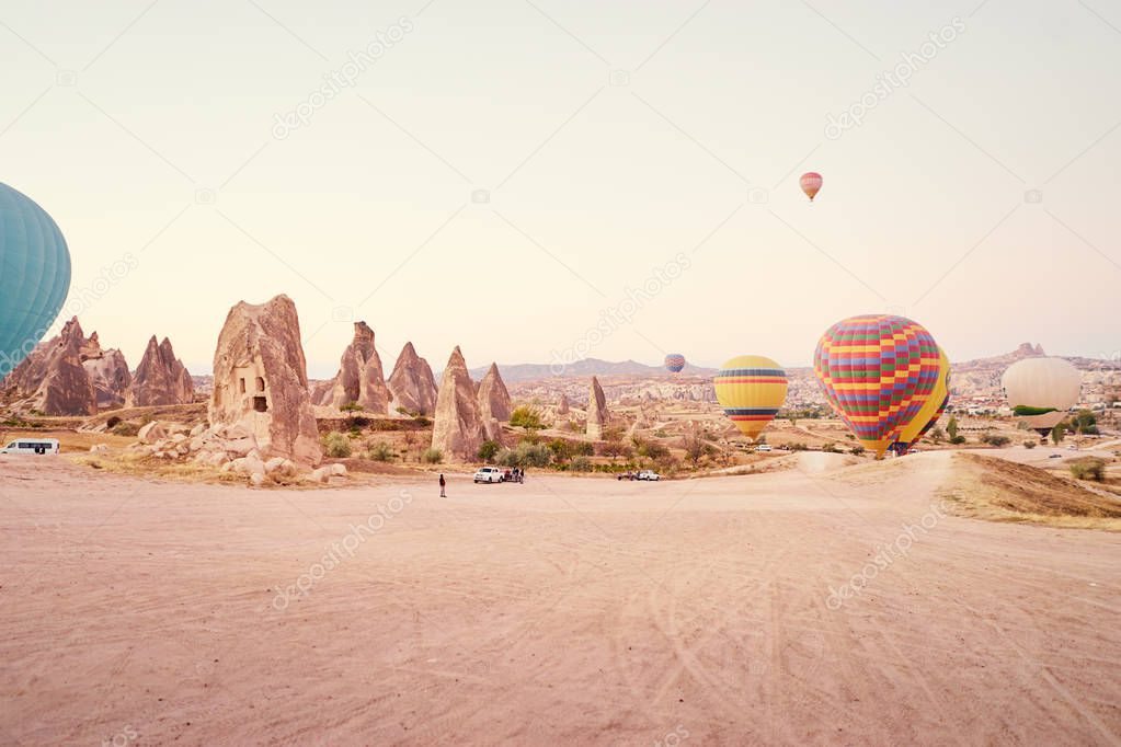 Famous sightseeing Cappadocia, Anatolia. Beautiful landscape with mountains, caves and balloons in the sky.