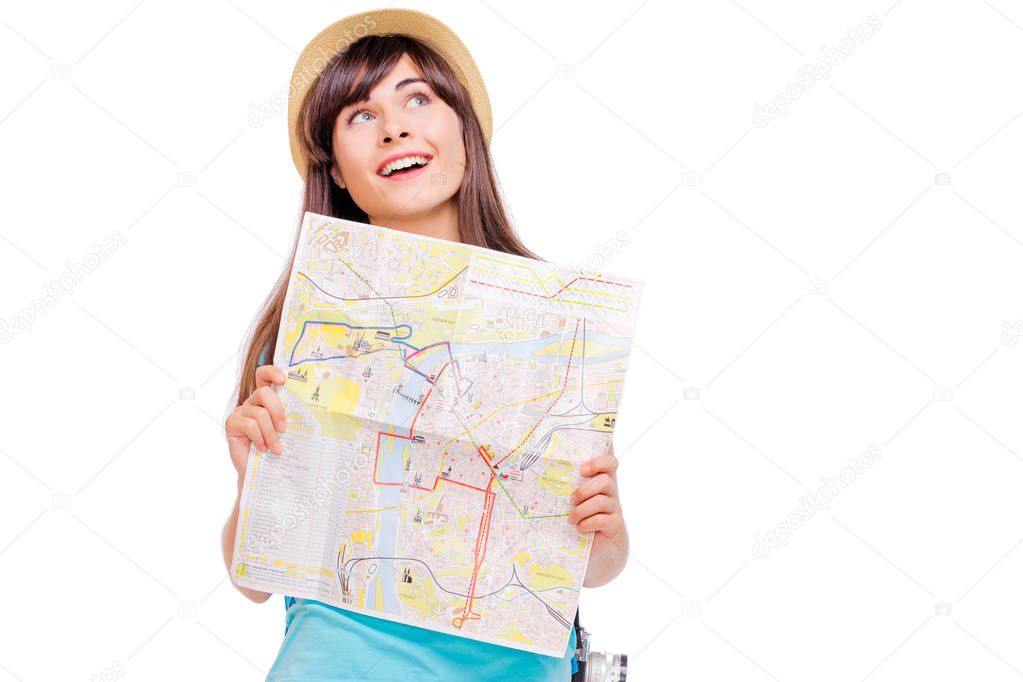 Studio portrait of pretty young woman holding map