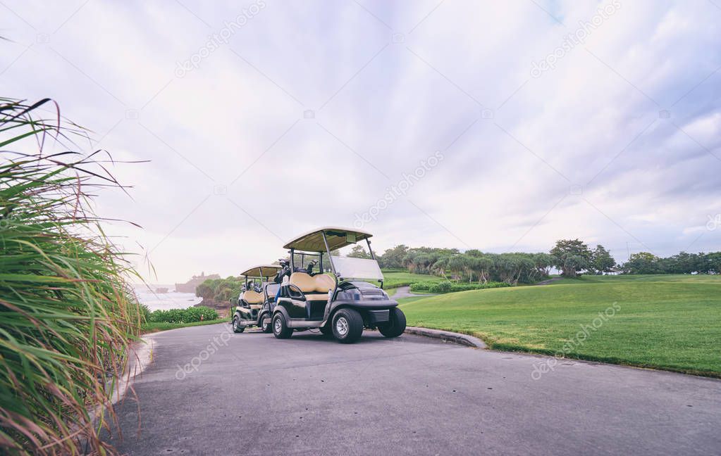 Scenic view of the golf course landscape with beautiful sky. Golf carts at the green golf course.