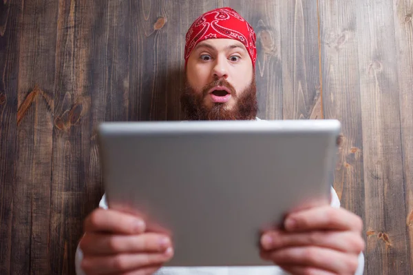 Junger Mann Mit Bart Überrascht Mit Digitalem Tablet Gegen Holzwand — Stockfoto