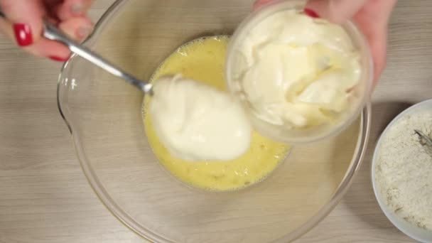 Add mayonnaise into the beaten eggs to prepare the dough for pizza — Stock Video