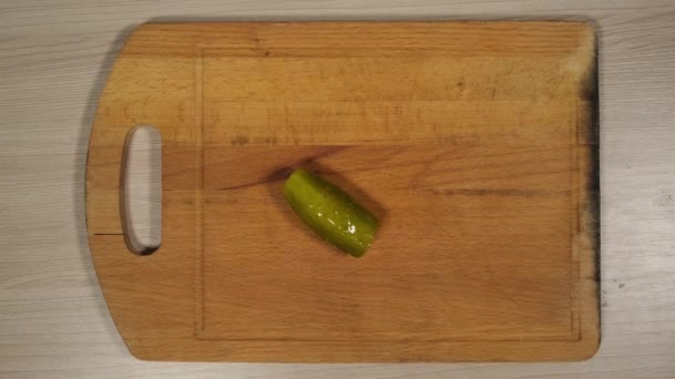 De vrouwenhanden sneden gesneden komkommer in kleine stukjes op een rode snijplank, close-up schot. De groene blokjes worden weerspiegeld in het mes.. — Stockvideo