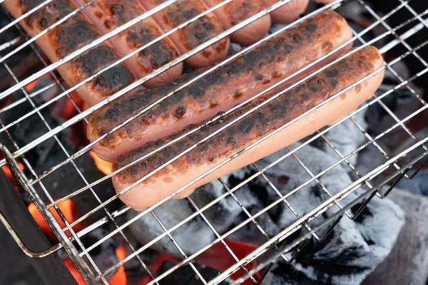 Barbekü ızgara üzerinde kömürler üzerinde cızırtılı lezzetli Alman sosis — Stok fotoğraf