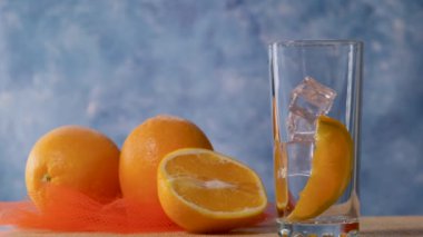 Sarı portakal limonata portakal ve buz ile berrak bir bardağa dökülür. Yavaş çekim.