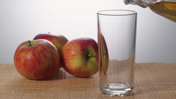 Яблучний сік насипають до половини склянки повільного руху — стокове відео