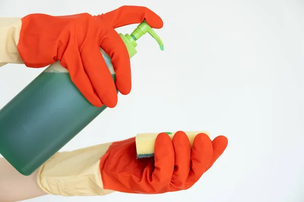 Manos en guantes para limpiar. Limpiador de superficies se vierte sobre una esponja. — Foto de Stock