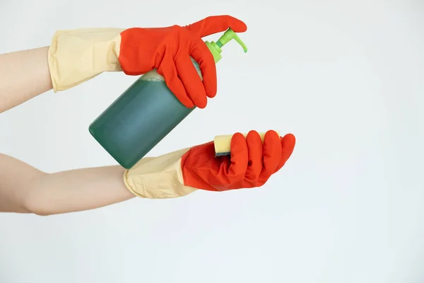 Manos en guantes para limpiar. Limpiador de superficies se vierte sobre una esponja. — Foto de Stock