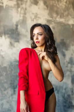 Petite beyaz esmer kız poz yarı-aşınmış duvar önce kırmızı ceket giymiş