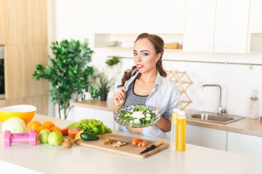 Mutfak yemek sırasında salata yemek minyon ve uygun esmer beyaz kız 
