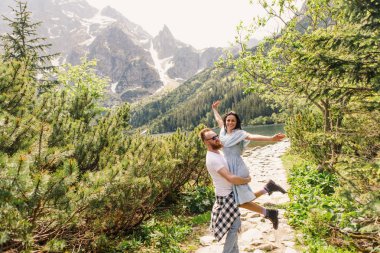 Norveç fiyordu sahili yakınındaki sarılma genç çift