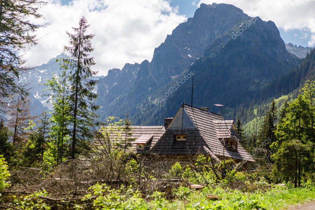 Breathetaking landscape of Tatra Mountains with wooden house in forest, Poland