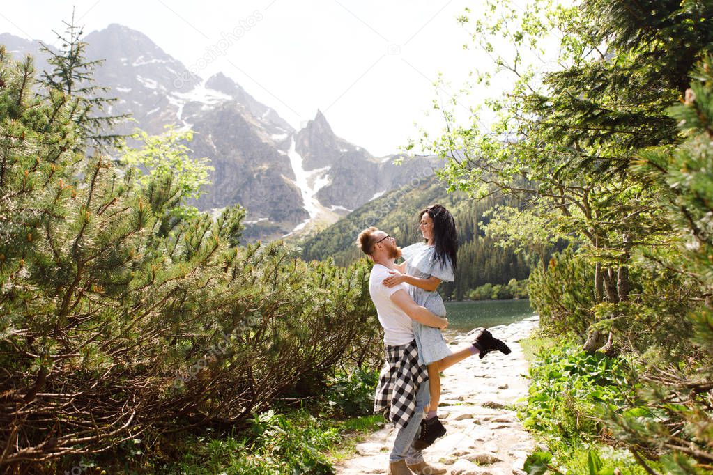 Young couple hugging near coastline in norwegian fjord