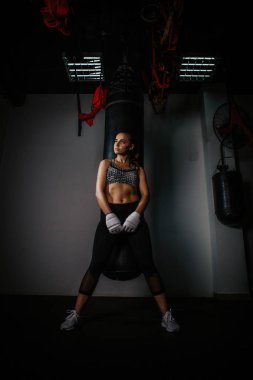 young beautiful girl boxer in a dark gym