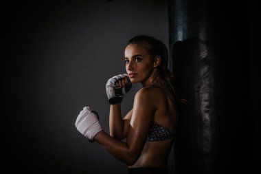 young beautiful girl boxer in a dark gym