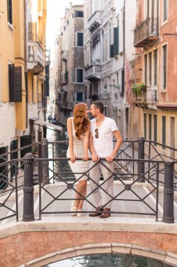 Genç çift üzerinde birbirlerine burun sürtme Venedik dar kanal üzerinden köprü