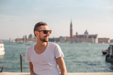 Şehrin arka planında güneş gözlüklü bir adam..