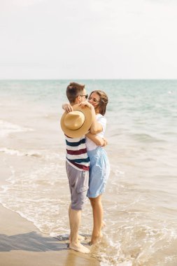 Genç bir çift deniz su hat boyunca çıplak ayakla yürümek