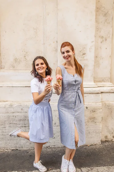 İki mutlu genç kız enjoing dondurma açık havada