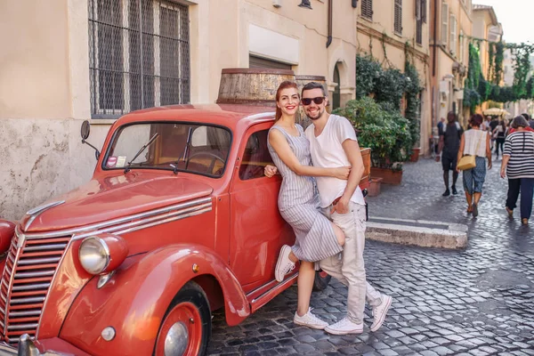 Pareja Joven Posando Cerca Coche Rojo Vintage Calle Empedrada —  Fotos de Stock