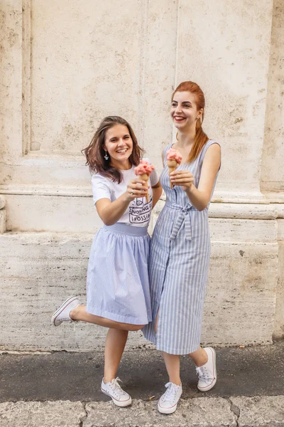 İki mutlu genç kız enjoing dondurma açık havada
