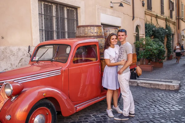 Giovane Coppia Posa Vicino Rosso Auto Epoca Strada Acciottolata — Foto Stock