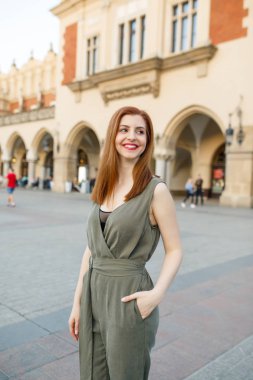 Mutlu traveler kız Ana Meydanı Krakow, Polonya üzerinde poz. Krakow Cloth Hall görünümüne