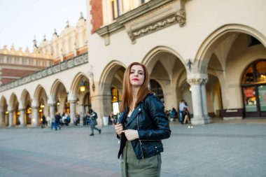 Mutlu traveler kız Ana Meydanı Krakow, Polonya üzerinde poz. Krakow Cloth Hall görünümüne