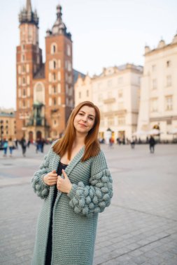 Mutlu traveler kız Ana Meydanı Krakow, Polonya üzerinde poz. Saint Mary Bazilikası görünümüne.
