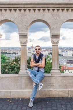 Genç adam Arcade gözlem güverte Budapeşte, Macaristan için poz