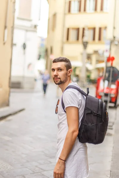 Side view of young man with backpack on street
