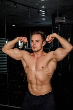 karanlık salonda duran genç erkek atlet