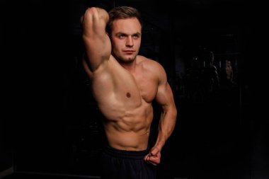 karanlık salonda duran genç erkek atlet