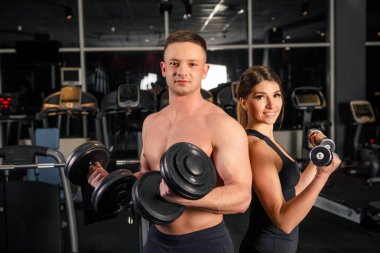 Genç güzel çift sporcular içinde karanlık bir spor salonunda egzersizleri yapıyor spor giyim