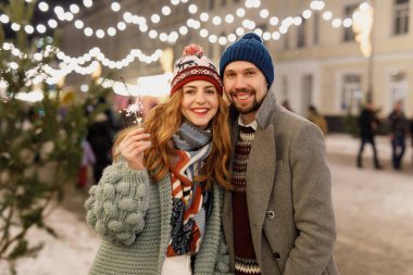 güzel kış giysileri, gri paltolu bir adam, ayakta dışında kış aylarında turkuaz bir hırka, bir kadında genç güzel çift