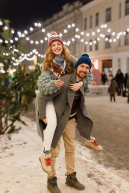 güzel kış giysileri, gri paltolu bir adam, ayakta dışında kış aylarında turkuaz bir hırka, bir kadında genç güzel çift